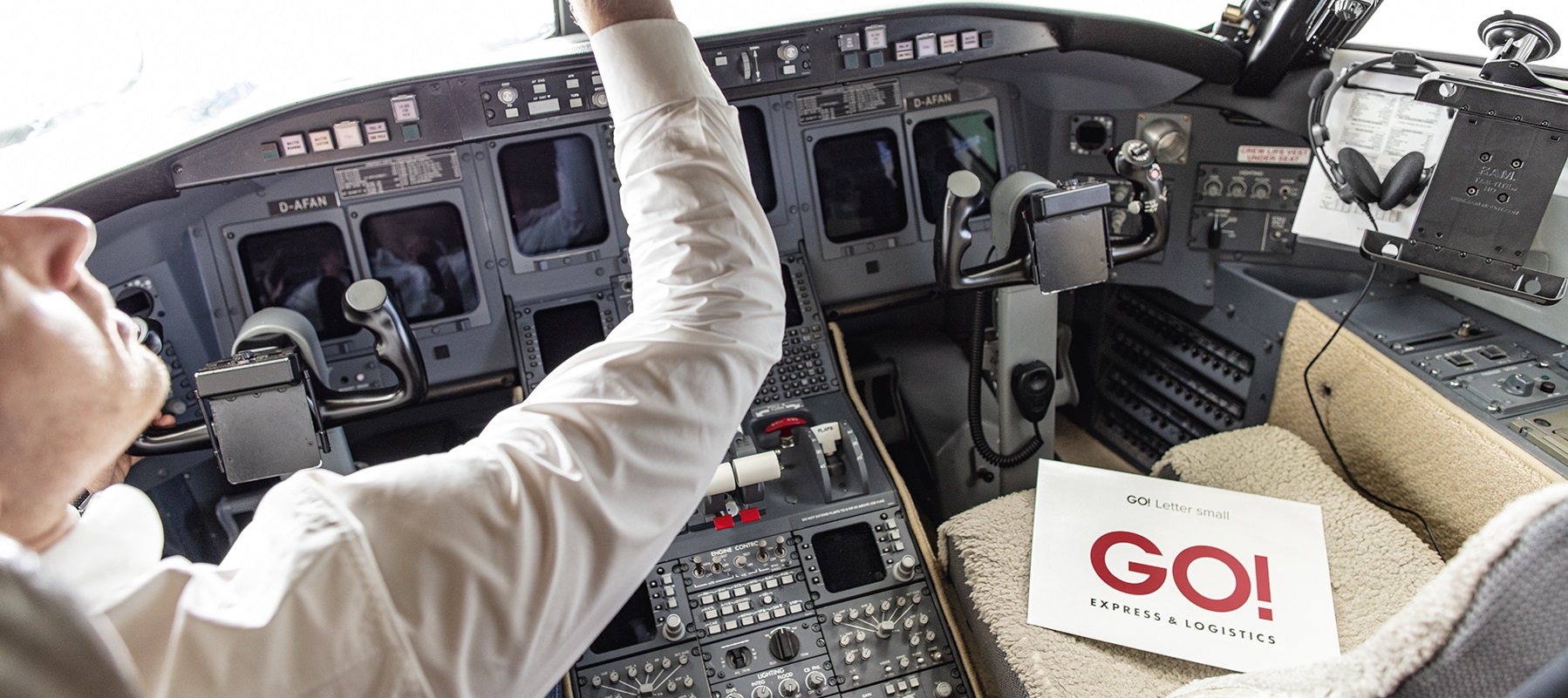 Pilot sitzt im Cockpit und ein GO! Letter liegt neben ihm auf dem Co-Pilotensitz